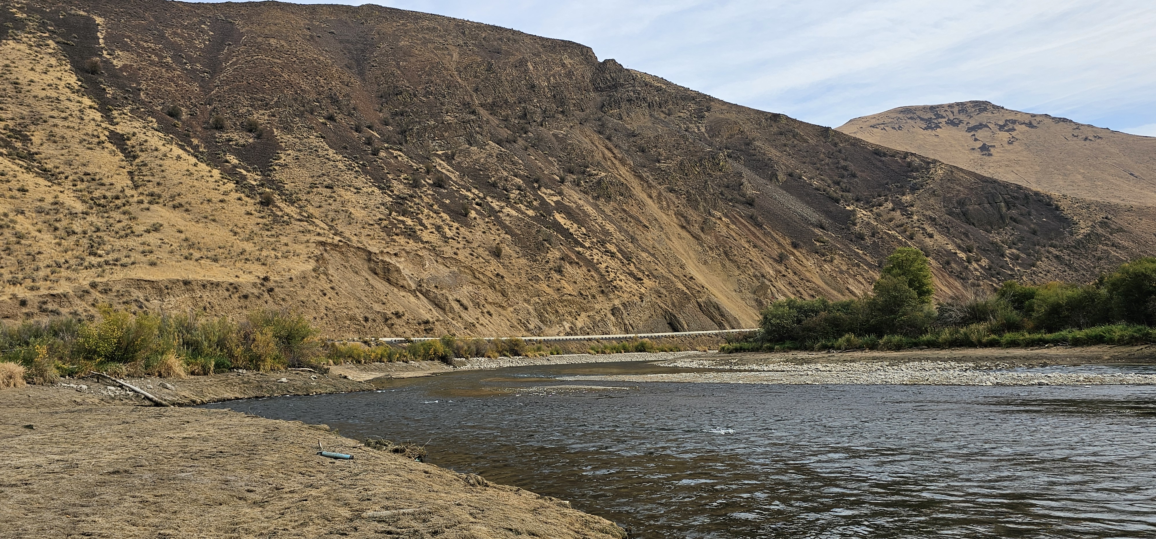 A river running through dry hills. 